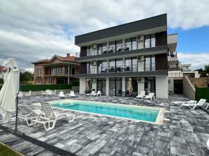 a house with a swimming pool in front of a house at Lakeview Apartments in Veles
