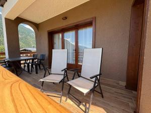 Zimmer mit Stühlen, einem Tisch und einem Balkon in der Unterkunft Mountain Garden Apartments Larice in Giustino