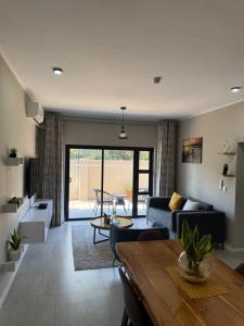 a living room with a couch and a table at Motswedi Place Apartments B4-Managed by Pulafela Prop Pty Ltd in Gaborone
