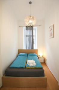 a bedroom with a bed with blue sheets and a chandelier at Downtown Bliss Modern Retreat with FREE parking and FAST Internet 600 MBits in Vienna