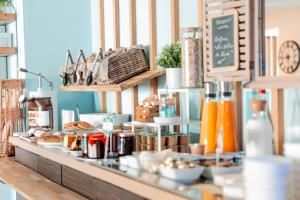 a bakery with a counter with food on it at Brit Hotel Confort Saint-Lô in Saint Lo