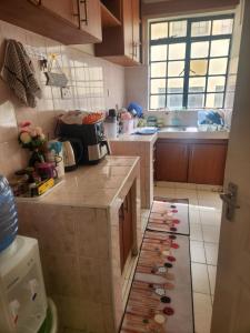 a kitchen with a counter with wine bottles on the floor at Cozzyville in Machakos