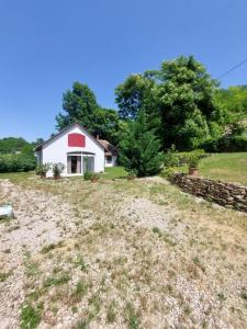ein Haus auf einem Feld mit einer Steinmauer in der Unterkunft Casa Georgio Vendégház in Szentgyörgyvár