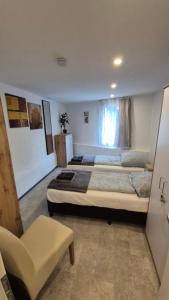 a large bedroom with two beds and a chair at Volkspark-3-Zimmer-Wohnung-4 Betten-Mainz in Mainz