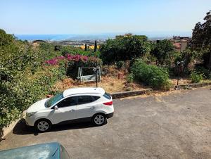 a white car parked in a parking lot at Santi Palace Apartment in Gravina di Catania