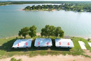 an overhead view of three tennis courts next to a lake at Oasis Lake Buchanan in Bluffton