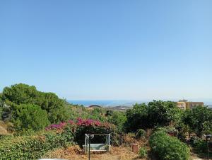 a bench sitting on top of a hill with flowers at Santi Palace Apartment in Gravina di Catania