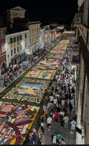 a crowd of people walking down a street with a large rug at Casa vacanza l’archetto in Genzano di Roma