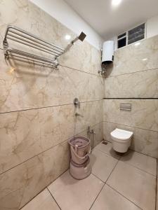 a bathroom with a toilet and a wall at Hotel Kusum Kunj in Ujjain +48 photos