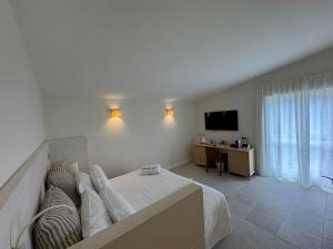 a bedroom with a bed and a desk and a television at Grand Hotel Aminta in Sorrento