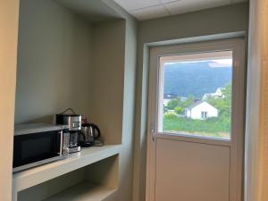 a door to a room with a microwave and a window at Åndalsnes house in Åndalsnes +20 photos