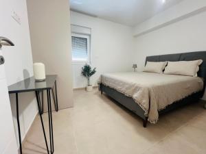 a bedroom with a bed and a desk in it at Apartmani Leon in Međugorje