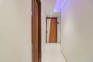 a hallway with a mirror and a door at Capital O Western Galaxy in Amritsar +60 photos