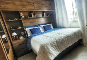 sypialnia z dużym łóżkiem i niebieskimi poduszkami w obiekcie Apartamento aconchegante ideal para casais w mieście Campos dos Goytacazes