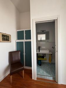 Guest House Emma في Boscotrecase: حمام مع حوض وكرسي ومرآة