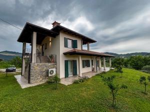 a house on a hill with a green field at Apartma Lavanda in Kojsko