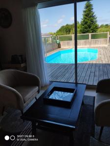 a living room with a view of a swimming pool at Violette et Bruno in Leulinghen-Bernes