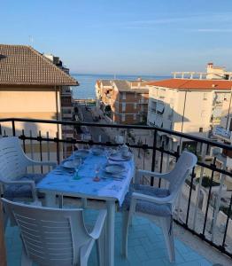une table et des chaises sur un balcon avec l'océan dans l'établissement Azure Stay, à Sperlonga