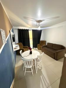 a living room with a table and a couch at Prainha - Apartamento 3 Quartos in Arraial do Cabo