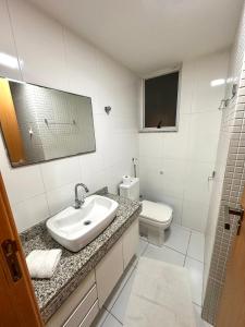 a bathroom with a sink and a toilet at Prainha - Apartamento 3 Quartos in Arraial do Cabo