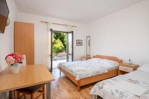 a bedroom with two beds and a table with flowers at Guest House Villa Bellevue 1 in Cavtat