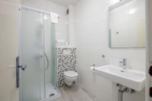a white bathroom with a toilet and a sink at Guest House Villa Bellevue 1 in Cavtat +18 photos