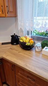a bowl of fruit sitting on top of a kitchen counter at Kaprys Apartament in Brenna +48 photos