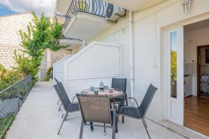a patio with a table and chairs on a balcony at Guest House Villa Bellevue 1 in Cavtat