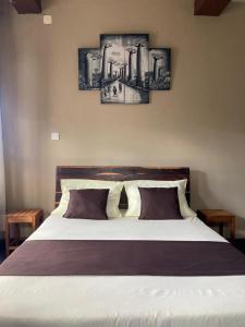 a bedroom with a bed with three pictures on the wall at Résidence Joie in Antananarivo