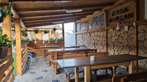 an empty restaurant with wooden tables and benches at Casa Adrian in Corbu
