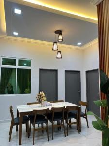 a dining room with a table and chairs at Nurul Ain Homestay, Nearby Kelulut Beach, Marang in Marang