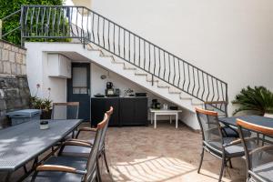 a patio with tables and chairs and a staircase at Guest House Villa Bellevue in Cavtat