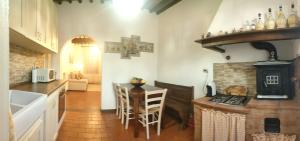 a kitchen with a stove and a table with chairs at CasaILARIAVicopisano in Vicopisano
