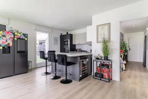 a kitchen with black appliances and black stools at Résidence Nimrod Abraham - ParisLaDefense in Colombes
