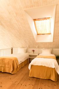 two beds in a attic bedroom with a skylight at Blomstertantens Hus in Trelleborg