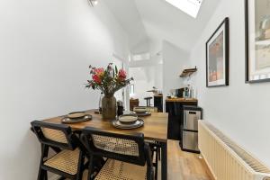 a dining room table with chairs and a vase of flowers at The Chatsworth Loft in Harrogate +21 photos