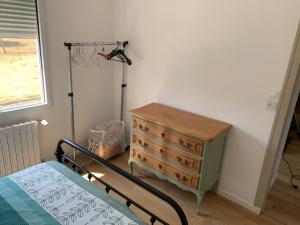 a bedroom with a bed and a dresser and a window at Ty Bihan Breizh in Pénestin