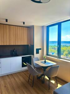 Una cocina y un comedor con mesa y sillas. en 1BR Luxury apartment with sea view and parking space, en Varna