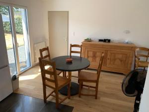 a room with a table and chairs and a kitchen at Ty Bihan Breizh in Pénestin +4 photos