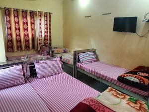 a room with three bunk beds and a flat screen tv at Ma manasha lodge in Guwahati