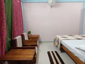 a bedroom with a bed and a table and a window at RUBANSi in Shillong +9 photos