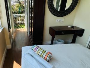 a bedroom with a bed with a mirror and a table at Ashby Manor Guest House in Cape Town +9 photos