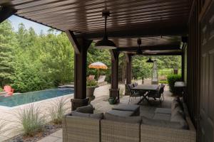 eine Terrasse mit Tisch und Stühlen neben einem Pool in der Unterkunft Cozy Private Suite with Year-Round Hot Tub in Elora