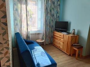 a living room with a blue couch and a television at Pokoje, apartamenty Aurelia 1km od Energylandii in Zator