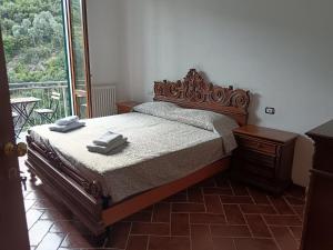 a bedroom with a bed with a wooden headboard and a window at Le Terrazze di katia rooms in Riomaggiore