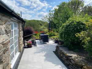 a pathway leading to a house with a table and plants at Garth Engan Private Self Contained B&B with Garden Area in Llanbedr