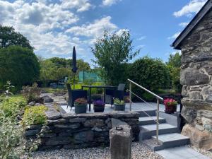 a garden with chairs and a table and stairs at Garth Engan Private Self Contained B&B with Garden Area in Llanbedr