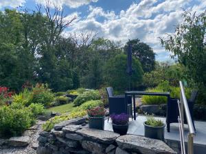a garden with chairs and flowers on a patio at Garth Engan Private Self Contained B&B with Garden Area in Llanbedr