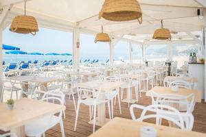 カステルデフェルスにあるBeach vibes in Castelldefelsの白いテーブルと椅子、そして海のあるレストラン