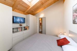 a bedroom with a bed and a tv on a wall at Residenza Cavour - Appartamento C in Tirano